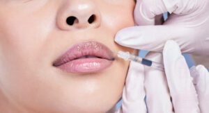 Closeup of a gorgeous mixed race woman getting botox filler in her face. Hispanic model getting cosmetic surgery getting lip fillers