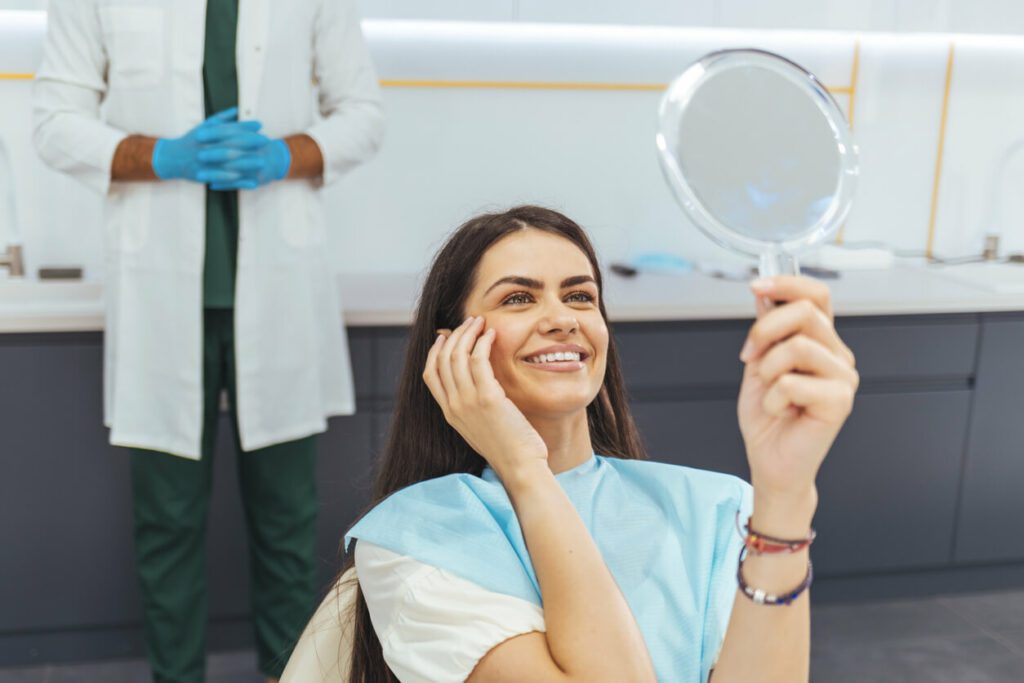 a happy woman admiring her face after dermal fillers