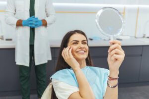 a happy woman admiring her face after dermal fillers